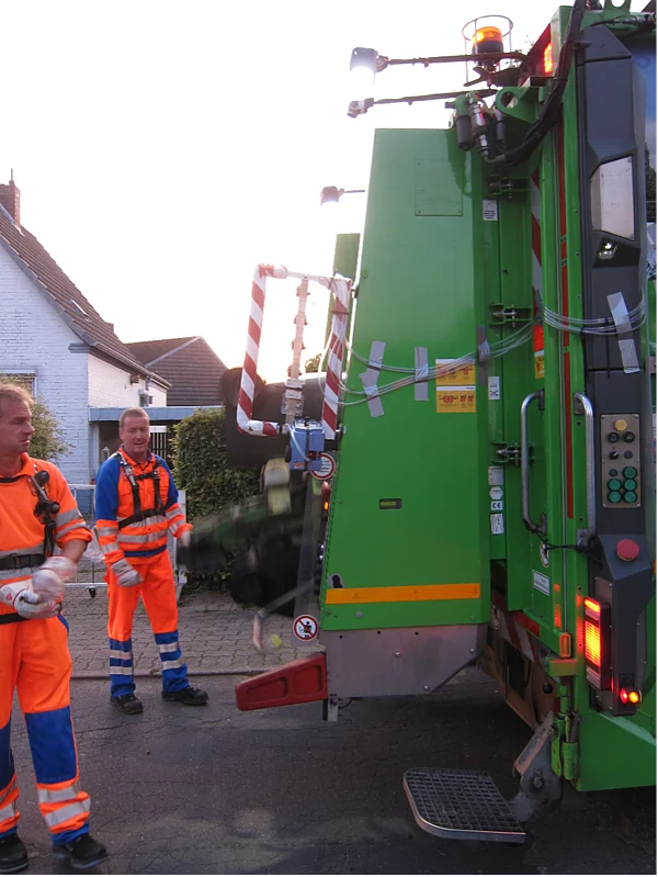 Mehrere Mitarbeiter der Müllabfuhr bei der Arbeit