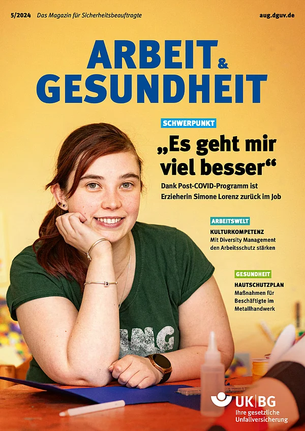 Titelbild des Magazins Arbeit & Gesundheit Ausgabe 5/2024. Oben der Titel "Arbeit & Gesundheit" auf gelbem Hintergrund. Im Zentrum lächelt eine junge Frau mit rotem Haar und grünem T-Shirt in die Kamera, gestützt auf eine Hand. Überschrift: „Es geht mir viel besser“ – ein Bericht über eine Erzieherin, die dank eines Post-COVID-Programms in ihren Job zurückkehrt. Weitere Themen: Kulturkompetenz im Arbeitsschutz und Hautschutzmaßnahmen für das Metallhandwerk.