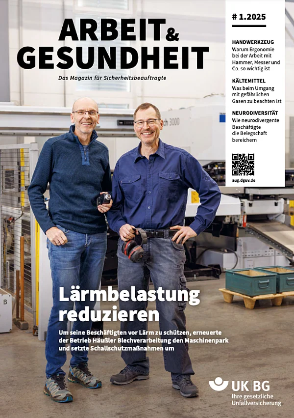 Zwei Männer in einer Werkstatt lächeln in die Kamera. Sie halten Werkzeuge in den Händen. Thema: Lärmschutzmaßnahmen in der Industrie.