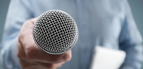 Foto einer Hand, die ein Mikrofon hält