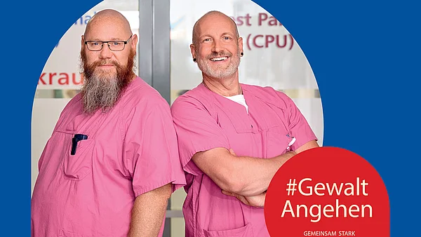 Zwei Klinikmitarbeitende posieren selbstbewusst. Schriftzug: Es geht euch alle an, wenn man mich angeht. #GewaltAngehen