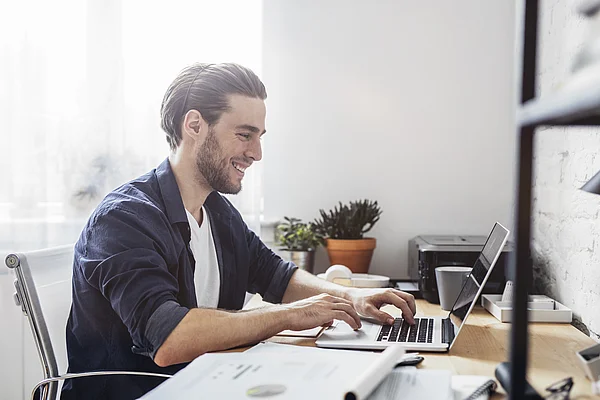 junger Mann sitzt am Schreibtisch