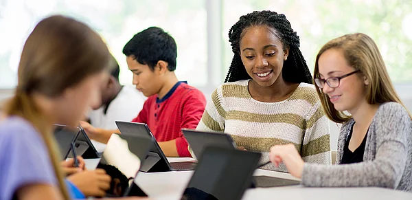 Schulkinder arbeiten im Klassenraum an Laptops