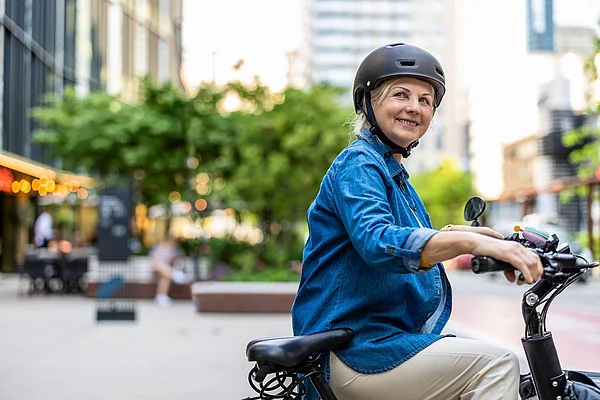 Radfahrerin mit Helm in der Stadt 
