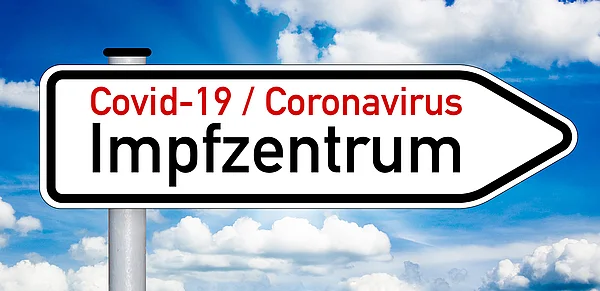 Wegweiser mit der Aufschrift "Impfzentrum"
