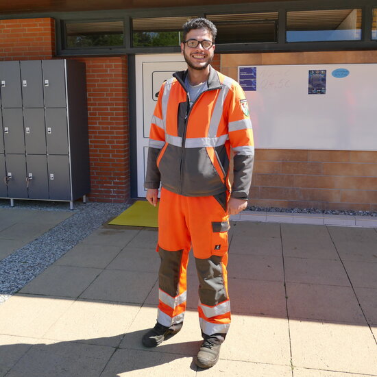Ein junger Mann in UV-abweisender Arbeitsschutzkleidung