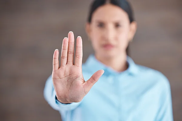 Frau hebt abwehrend die Hand