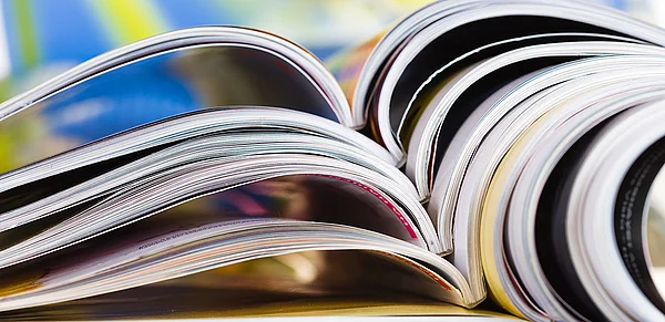 Ein Stapel aufgeschlagener Zeitschriften